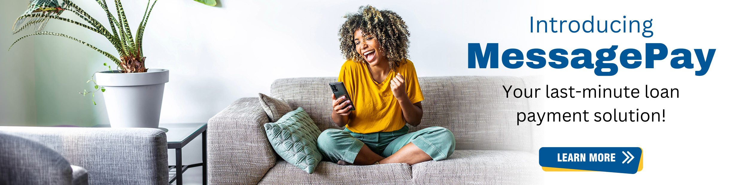 Excited woman sitting indian style on couch looking at her phone.