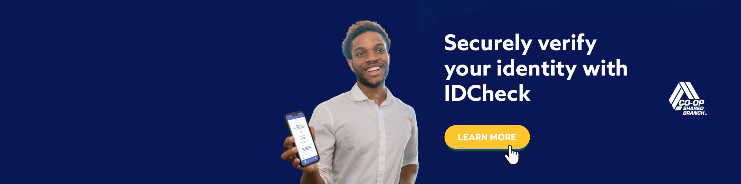 Middle aged African American man holding up his cell phone in a bank-like setting.