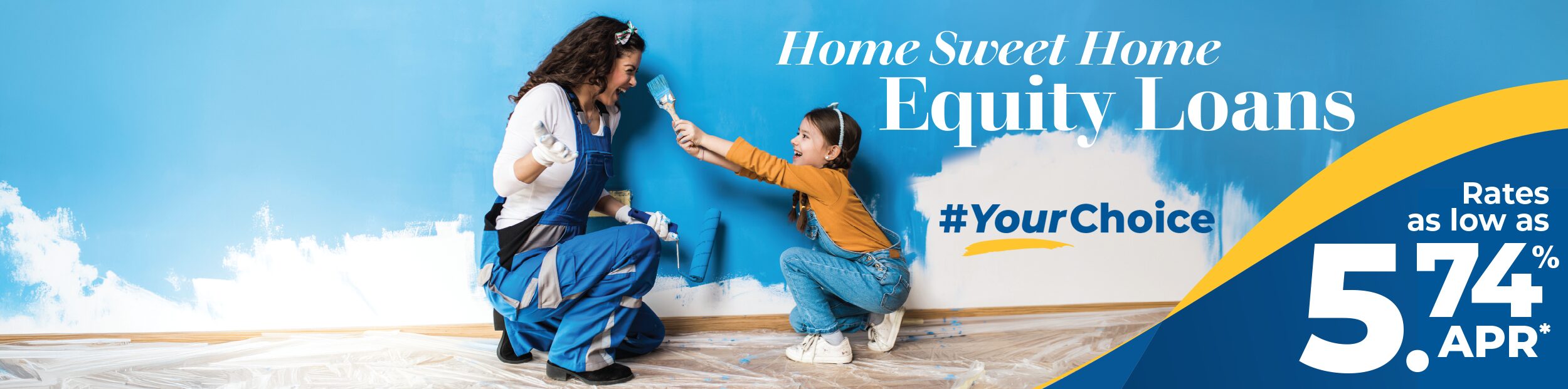 Mother and daughter having fun painting a wall the color blue.